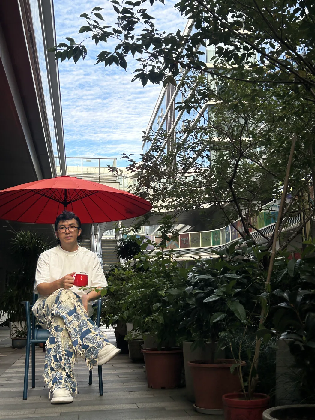 老爷子在咖啡馆外的树荫下走动